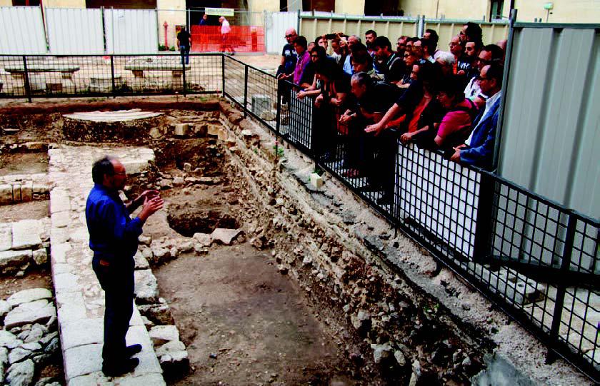 Uomo parla su sito archeologico e studenti ascoltano 