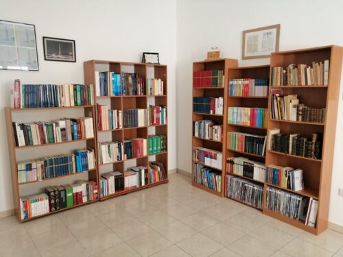 Librerie con libri adagiate su due pareti perpendicolari