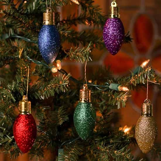Riciclo di vecchie lampadine glitterate appese su rami dell'albero natalizio