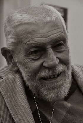 Fotografia in bianco e nero di uomo anziano magro con barba e pochi capelli