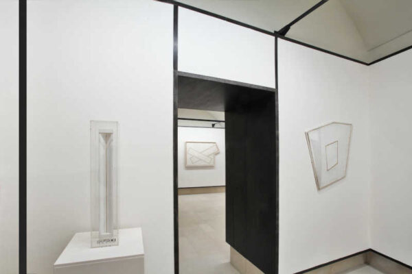 Sala espositiva con scultura e opere pittoriche alle pareti con predominanza di bianco