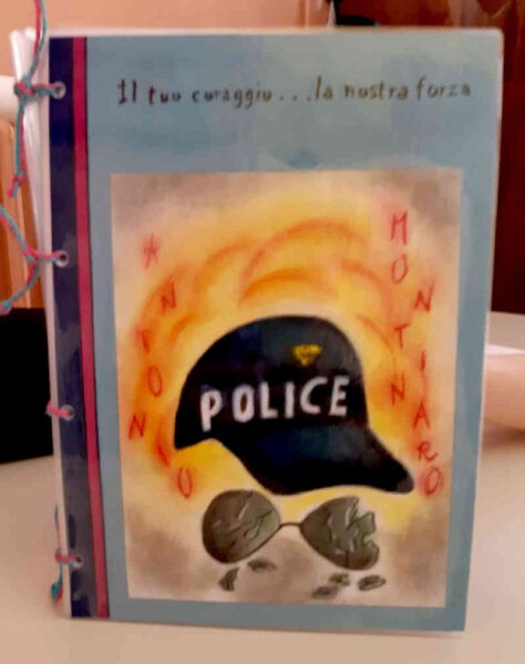 copertina di libro rilegato con nastri tricolori e copertina con cappellino con visiera e occhiali da sole fantumati