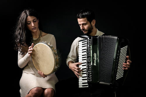Foto con sfondo nero Rachele Andrioli Suona il tamburello e Rocco Nigro suona la fisarmonica